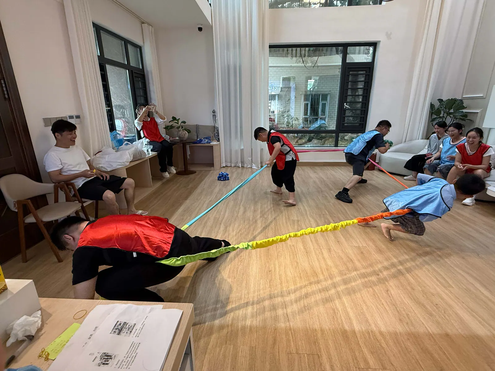 Team members reacting to changing directions inside large elastic bands during an indoor game
